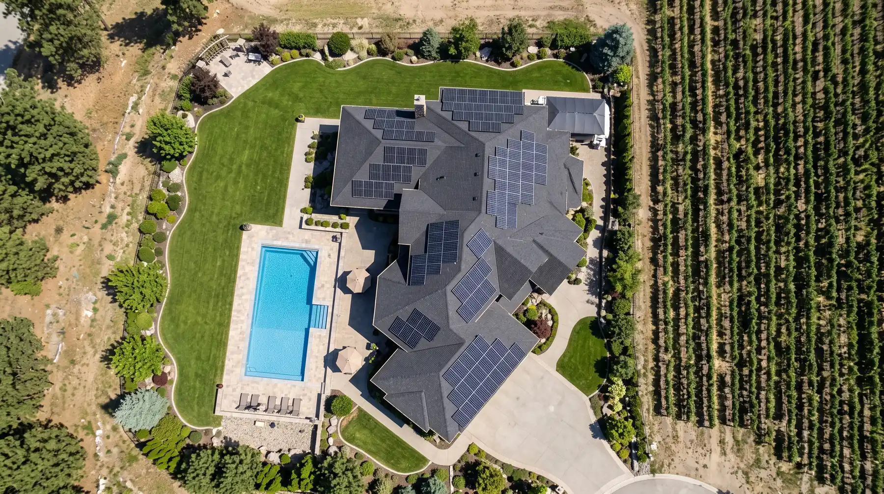 Aerial view of a Kelowna home with solar panels on two roof planes