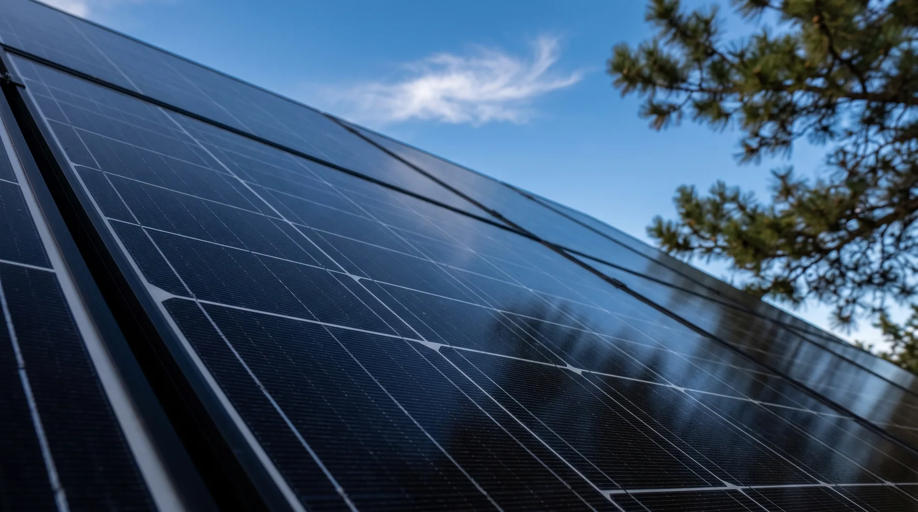 Close-up of solar panel glass reflecting a blue sky